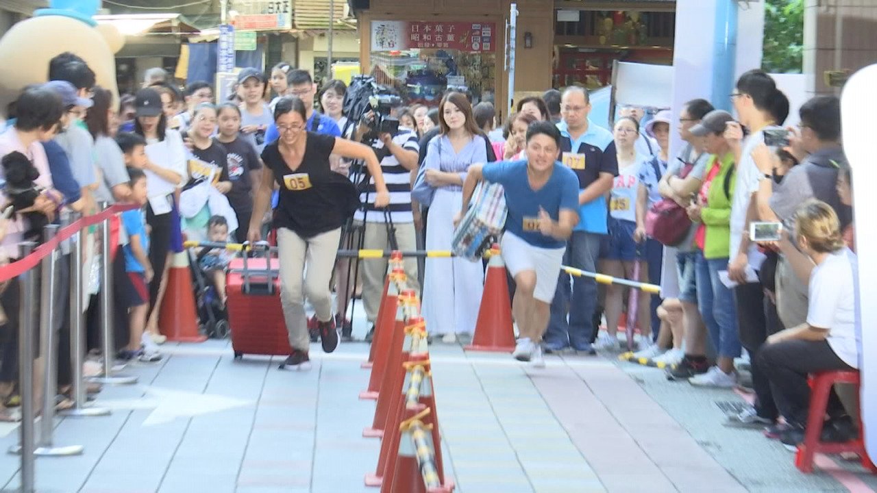 Taipei shopping district marks holiday with suitcase-carrying race