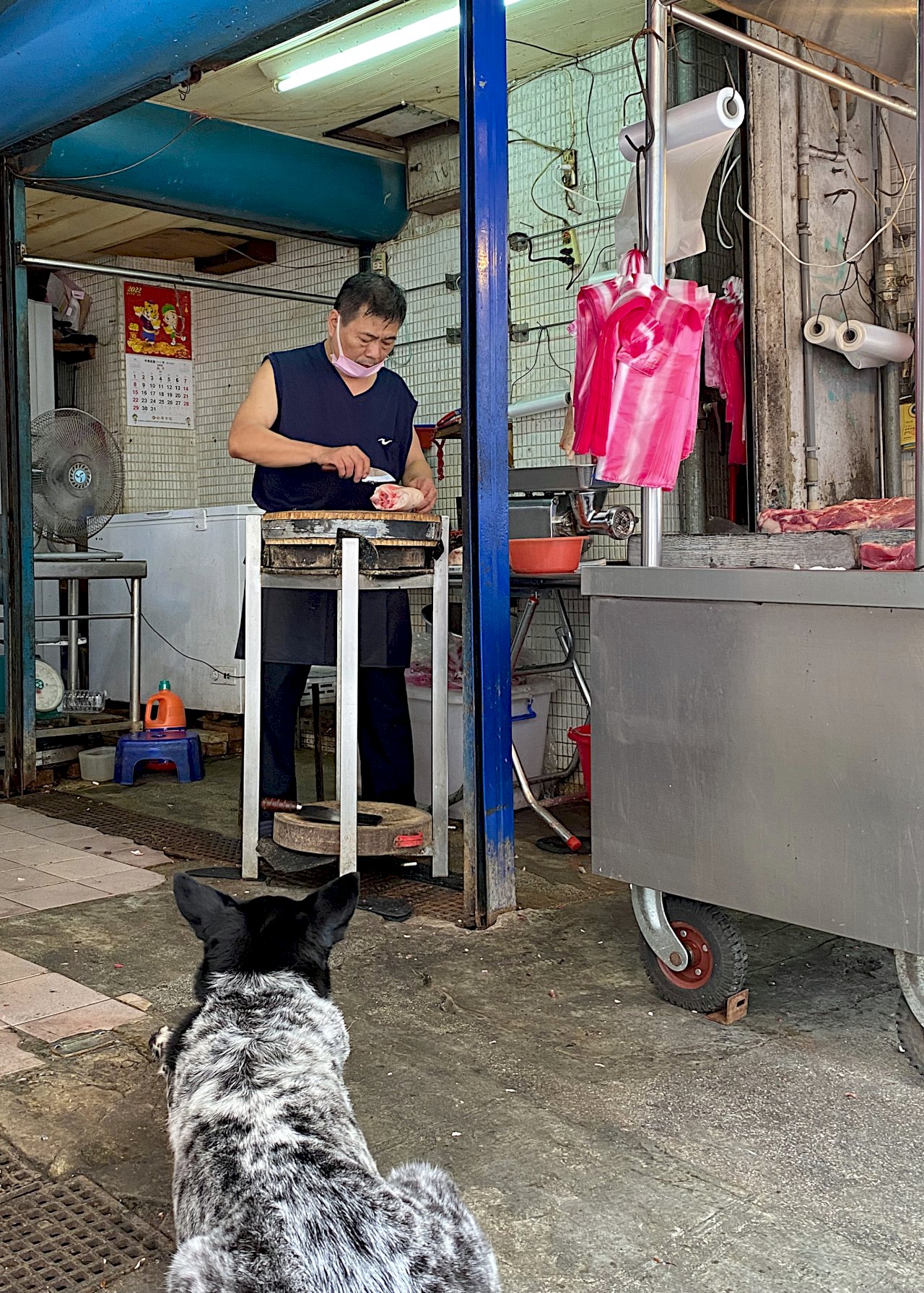 Butcher chops meat for a regular customer